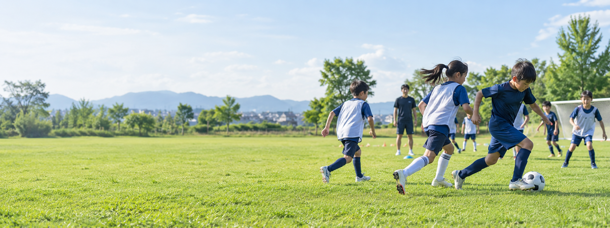 芝生のグラウンドで練習するジュニアサッカーチーム